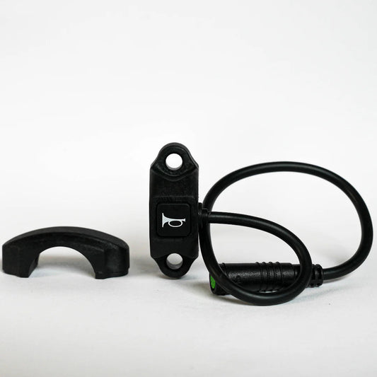 Close-up of a Super73 e-bike handlebar featuring a mounted horn switch with wiring attached.