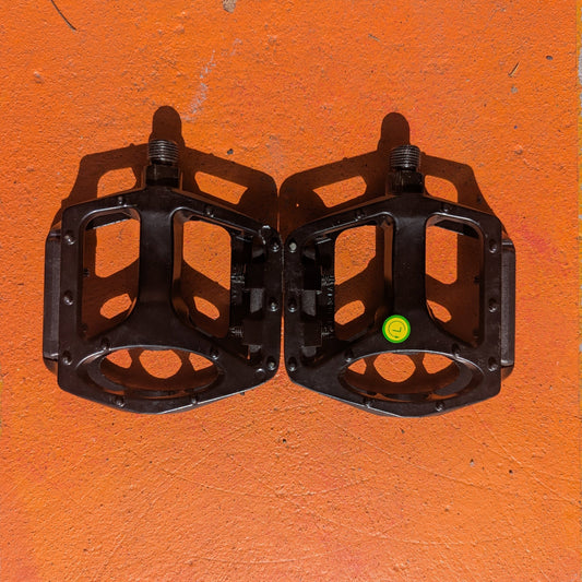 A pair of metal eBike pedals in a sleek, modern design, featuring a textured surface and open frame for enhanced grip and durability.