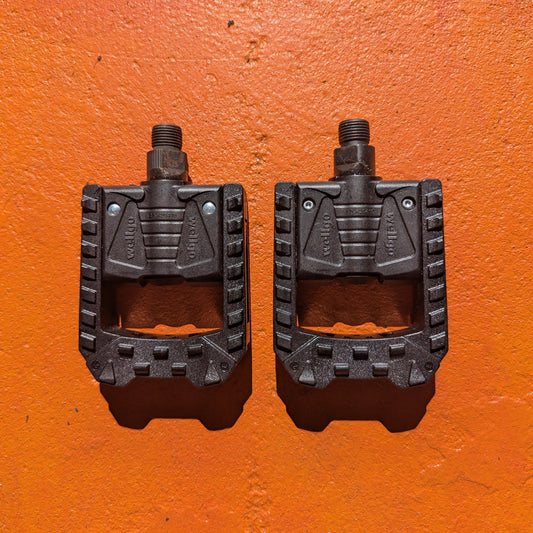 Folding nylon eBike pedal in a partially folded position, showing textured surface and metal hinge mechanism.