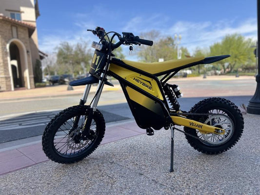 A sleek black eMOTO Yozma electric motorcycle parked on a white background, showcasing its modern design and angular bodywork.