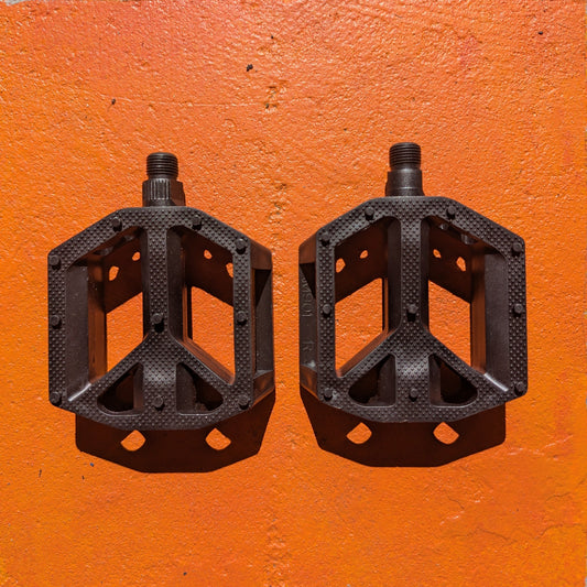 Black nylon eBike pedal with textured surface and reflectors, shown from a side angle on a white background.